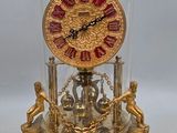 une horloge placée sous un dôme de verre sur une table