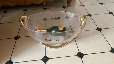 a glass bowl with a bottle in it on the floor