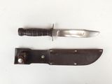 a knife and a knife holder on a white surface