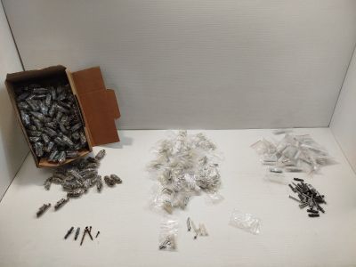 une boîte pleine de vis et des vis posées sur une table