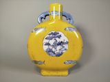 un vase jaune orné d'un motif bleu et blanc