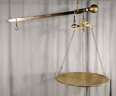 une balance en or dont pendent des chaînes de chaque côté