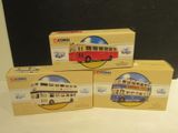 three boxed model buses sitting on top of each other on a table