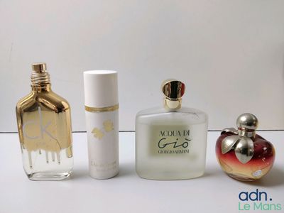 trois flacons de parfum différents posés les uns à côté des autres sur une table