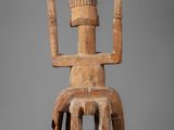 a wooden sculpture of a man with a hat on his head