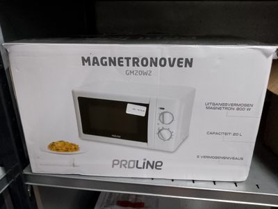 un carton contenant un micro-ondes posé sur une étagère