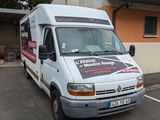 une camionnette blanche garée sur un parking à côté d'un bâtiment