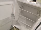 a white refrigerator with its door open in a kitchen