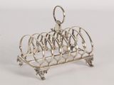 a silver plated toaster that has a bunch of toasting utensils on it