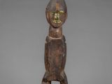 a wooden statue of a man with a green face