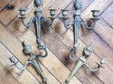 three antique cast iron candelabs on a wooden floor