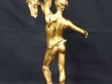 a gold statue of a man holding a bird on a rock