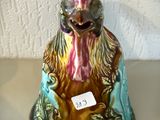 une figurine représentant un coq, à laquelle est attachée une étiquette