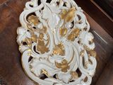 a white and gold plate sitting on top of a wooden chair