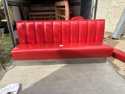 a red bench that is sitting in the back of a truck