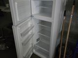 un réfrigérateur blanc dont la porte est ouverte, dans une pièce