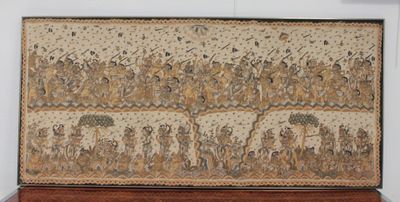 une tapisserie exposée dans un musée, posée sur un socle en bois