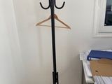 un porte-manteau muni d'un cintre, placé dans un coin de la pièce
