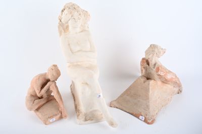 three clay figurines of a man and a woman sitting on a bench