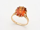une bague en or sertie d'une pierre orange entourée d'un diamant