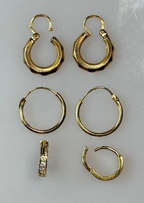 three pairs of gold hoop earrings and a pair of gold hoop earrings
