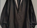 a black jacket hanging on a wall next to a coat rack