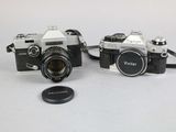 two cameras sitting next to each other on a table