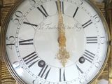 a gold clock with roman numerals on the face