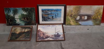 de nombreux tableaux posés par terre près d'un mur rouge