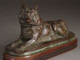 bronze statue of a dog on a wooden base on a table