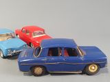several toy cars are lined up in a row on a gray surface