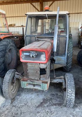 un tracteur garé dans une grange avec d'autres tracteurs
