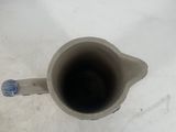 a cup that is sitting on the floor next to a bottle