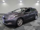 the grey car is parked on a checkered floor in a garage