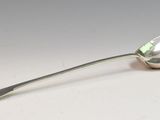 a silver spoon with a spoon handle on a white surface