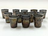 Plusieurs verres à shot sont alignés en cercle sur une surface blanche
