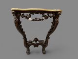 an ornately carved console table with a marble top
