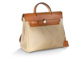 Le petit sac beige est posé sur une surface blanche.