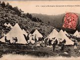 une vieille carte postale représentant un groupe de personnes debout devant un ensemble de tentes