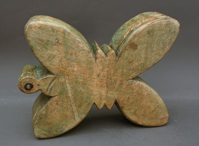 sculpture représentant un papillon, réalisée en argile verte et dotée d'un œil marron