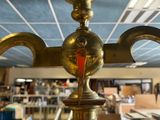 a gold candle holder with a red candle on it