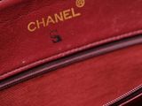 the inside of a red purse with a gold chain on it