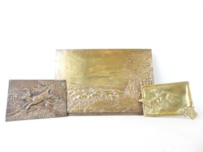 three pieces of gold metal with a picture of a man and a dog