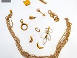 a lot of gold jewelry on a white surface