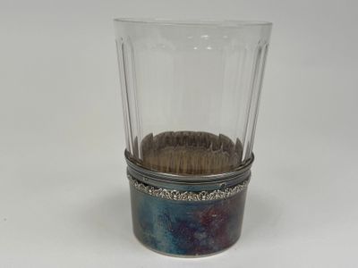un verre contenant un pinceau, posé sur une table