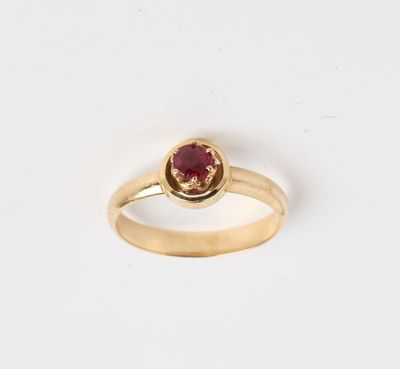 une bague en or avec une pierre rouge au centre