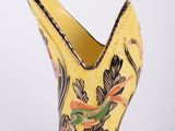 une image représentant un vase jaune orné d'un motif d'oiseau