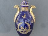 un vase bleu orné d'une décoration dorée