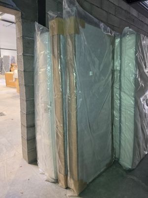 many mattresses wrapped up in plastic in a warehouse
