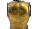 a gold vase sitting on a white surface with a white background